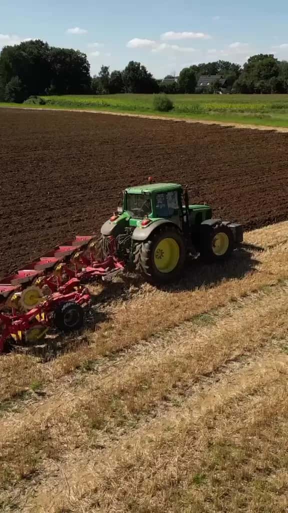 Traktor mit Pflug beim Wenden des Bodens